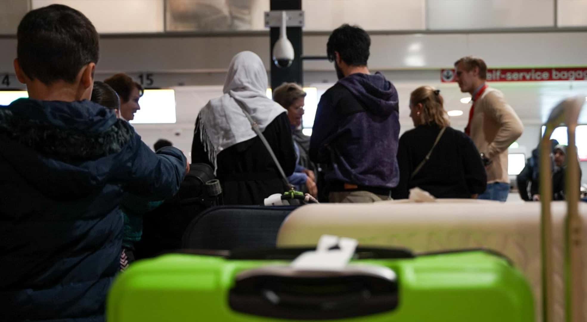Vertrekkende mensen met bagage in de vertrekhal van een vliegveld