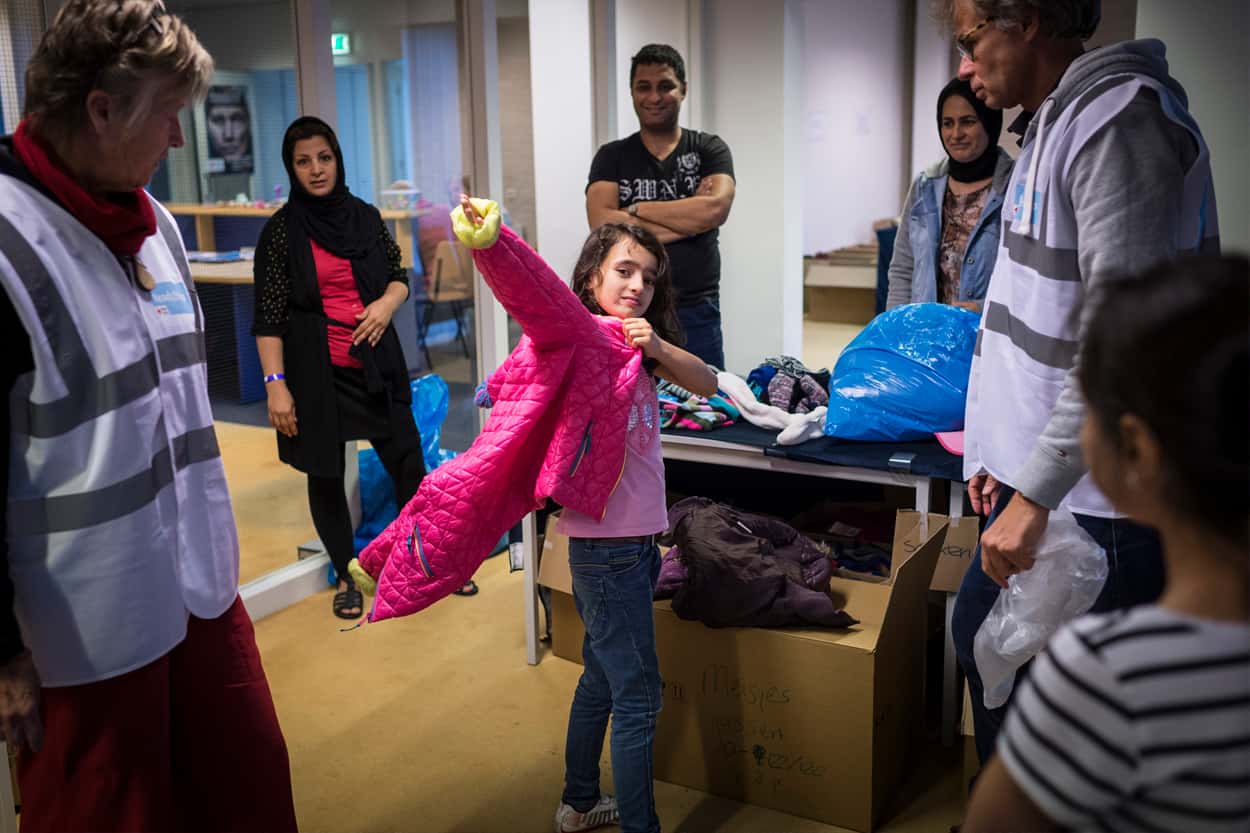 Een meisje trekt een jas aan